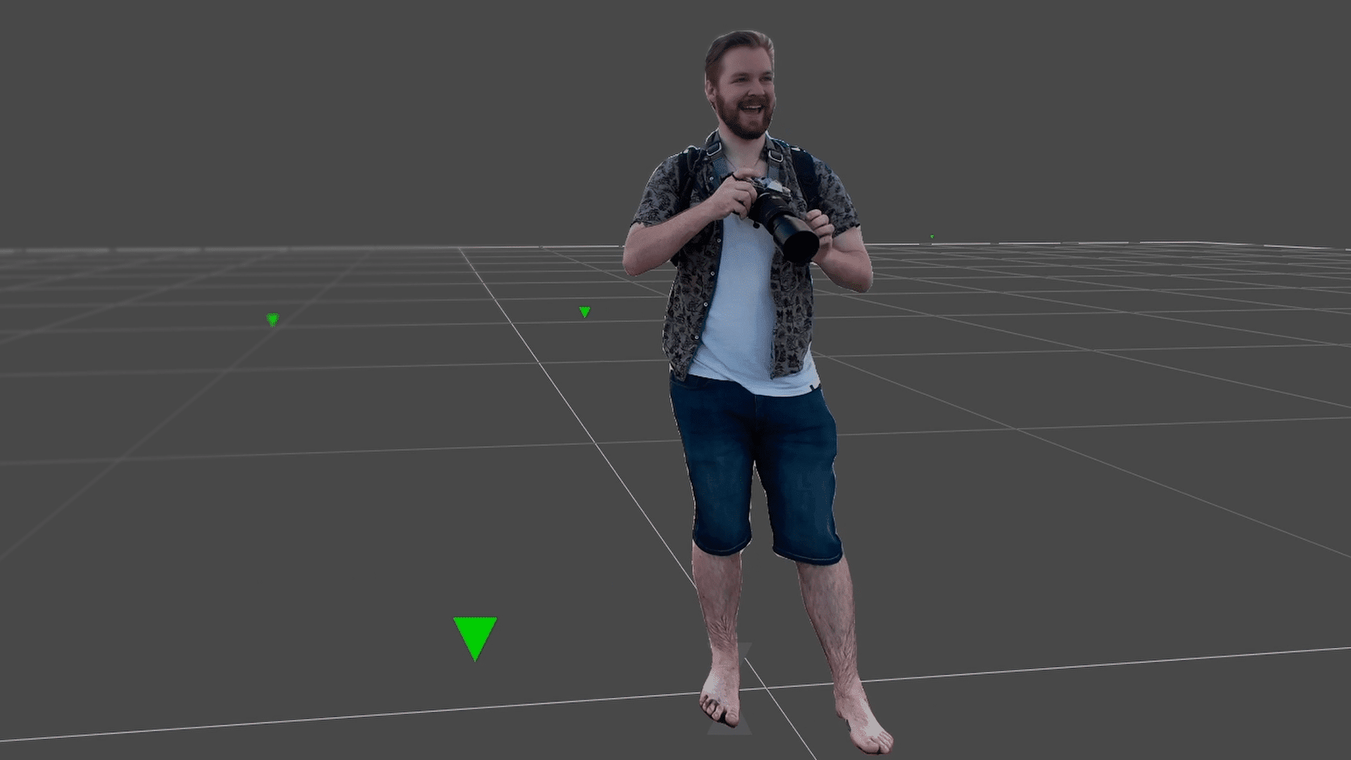 a man standing barefoot in a virtual environment holding a camera he is wearing a shortsleeved patterned shirt and denim shorts with a grid pattern visible on the ground around him green markers are placed in the scene digital production A man standing barefoot in a virtual environment, holding a camera. He is wearing a short-sleeved patterned shirt and denim shorts, with a grid pattern visible on the ground around him. Green markers are placed in the scene.