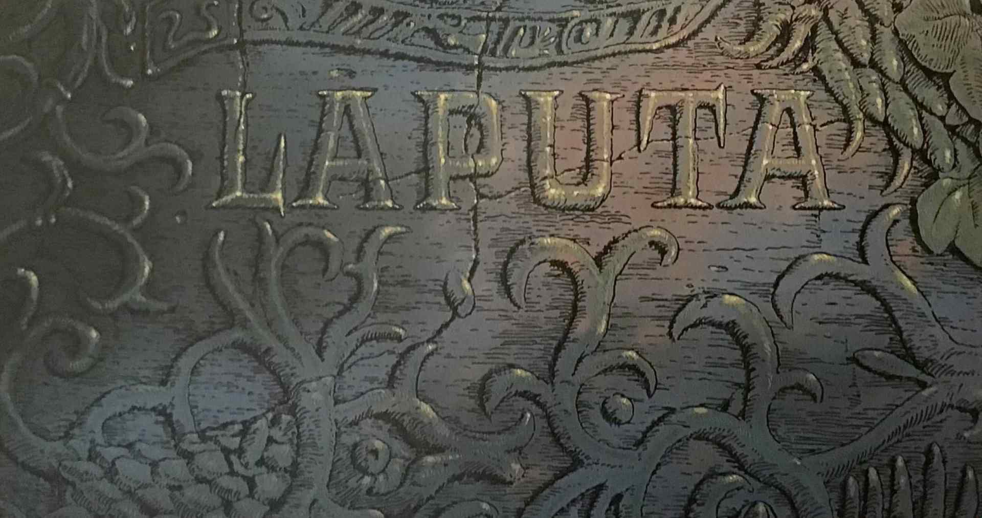 closeup of a wooden surface engraved with intricate designs and the word laputa prominently displayed in capital letters digital production Close-up of a wooden surface engraved with intricate designs and the word "LAPUTA" prominently displayed in capital letters.