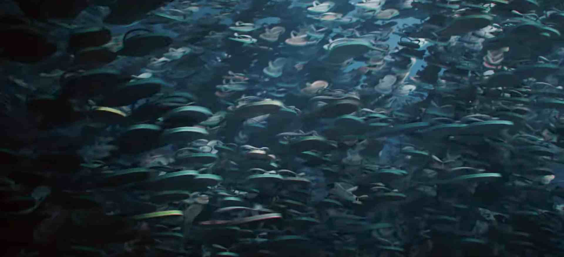 a school of fish swimming underwater with varying colors and shapes seen in a dimly lit environment the surface light creates a shimmering effect on the water digital production A school of fish swimming underwater, with varying colors and shapes seen in a dimly lit environment. The surface light creates a shimmering effect on the water.