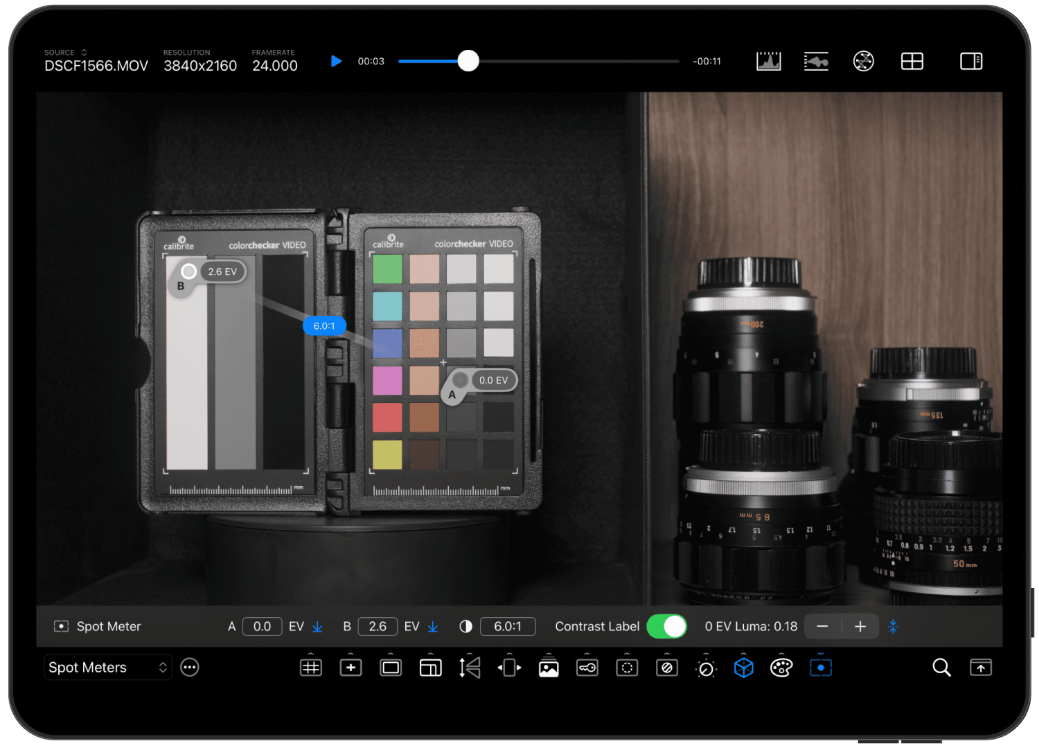 a tablet screen displaying a color checker with grayscale and color patches alongside camera lens equipment the interface shows exposure settings and spot meter readings at the bottom digital production A tablet screen displaying a color checker with grayscale and color patches, alongside camera lens equipment. The interface shows exposure settings and spot meter readings at the bottom.