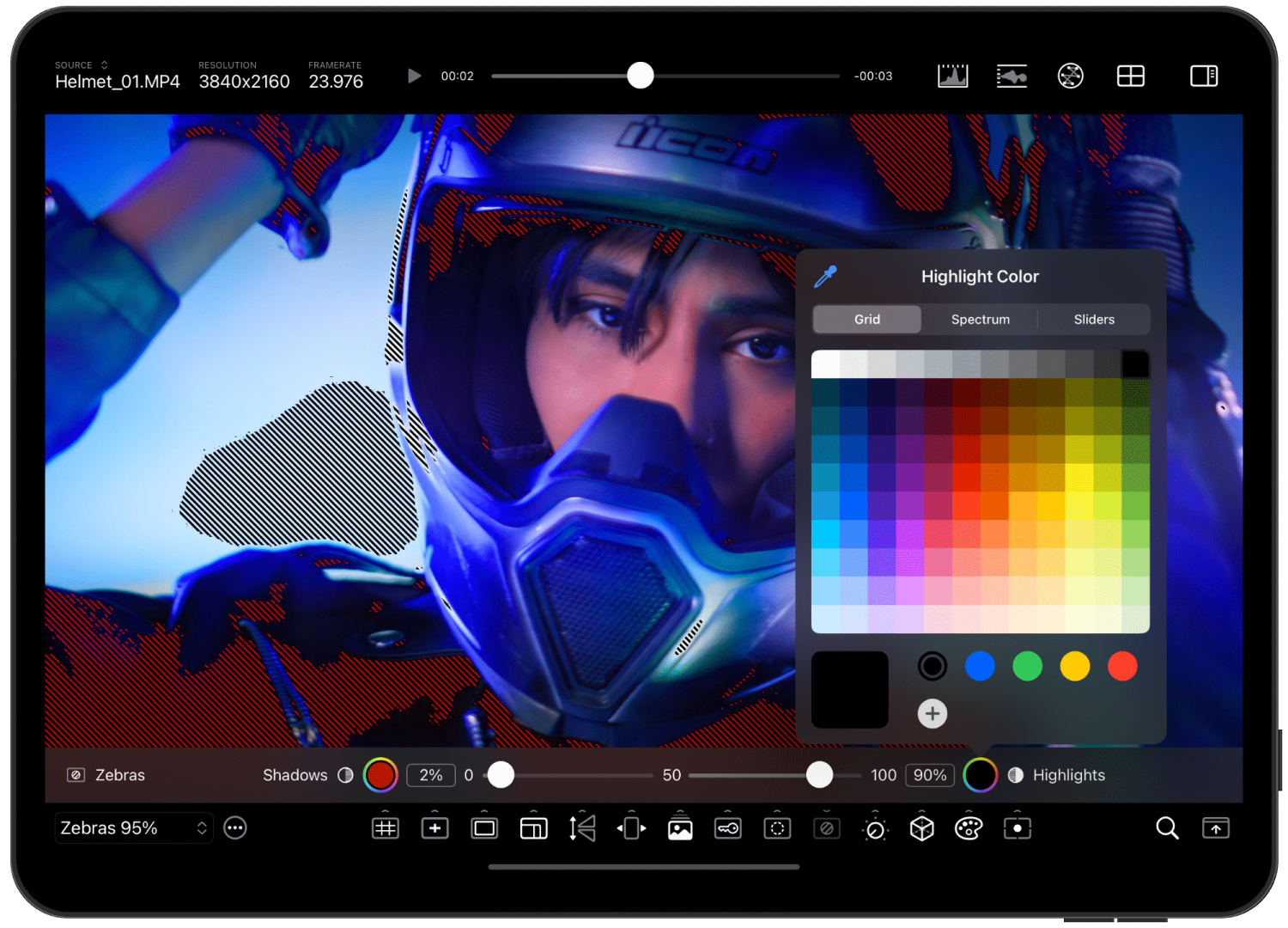 a closeup view of a person wearing a helmet and goggles with editing software displayed on a tablet screen color adjustment tools and a color palette are visible in the interface digital production A close-up view of a person wearing a helmet and goggles, with editing software displayed on a tablet screen. Color adjustment tools and a color palette are visible in the interface.