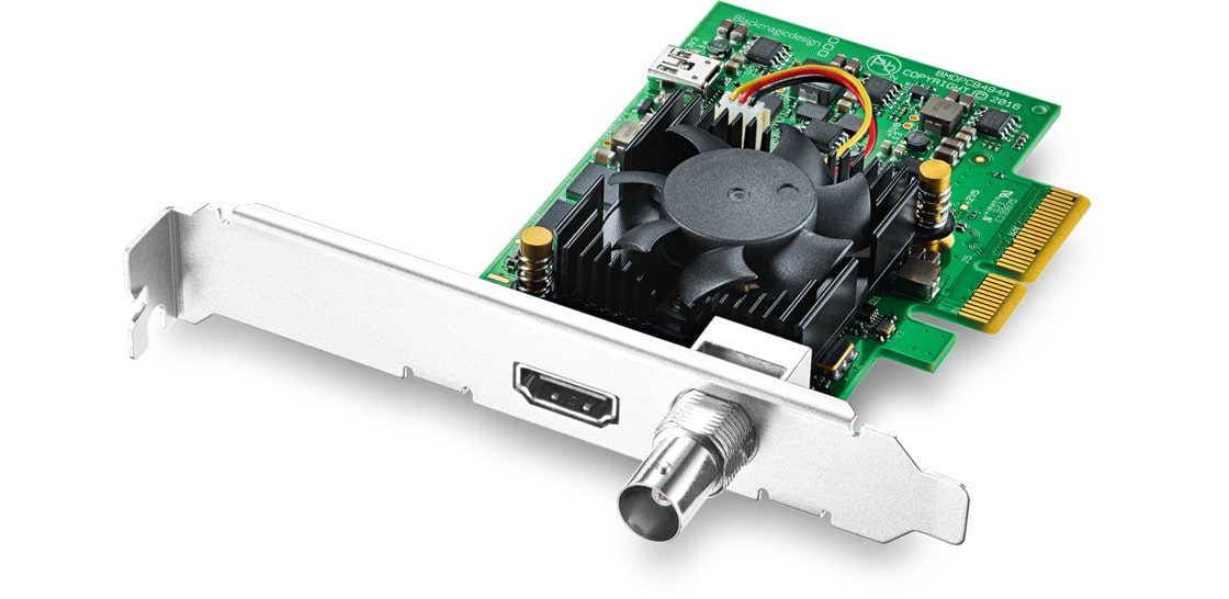 a computer graphics card featuring a green circuit board a large black cooling fan and multiple connectivity ports including an hdmi and a bnc connector at one end digital production A computer graphics card featuring a green circuit board, a large black cooling fan, and multiple connectivity ports including an HDMI and a BNC connector at one end.