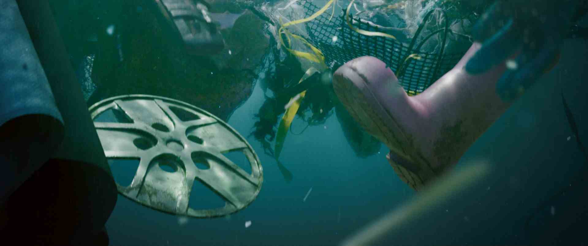 underwater view showing various debris including a plastic film reel and a pink rubber boot along with fishing nets and other discarded items bubbles and sediment are visible in the water digital production Underwater view showing various debris, including a plastic film reel and a pink rubber boot, along with fishing nets and other discarded items. Bubbles and sediment are visible in the water.