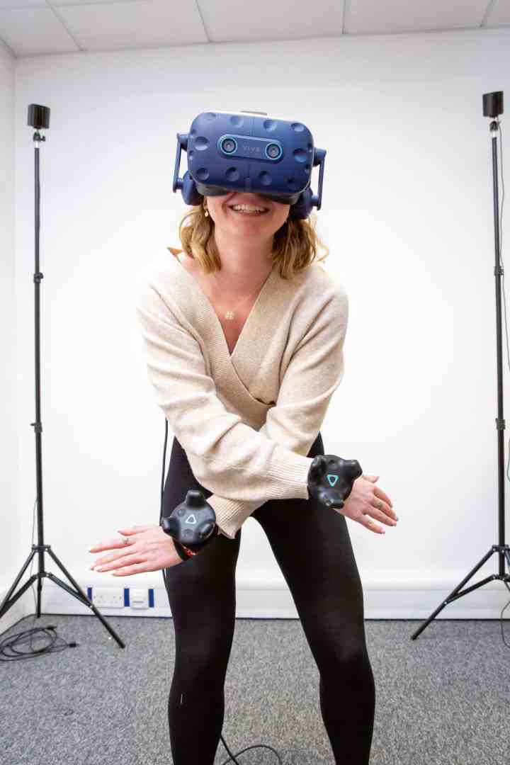 a woman wearing a virtual reality headset with motion sensors in a studio setting digital production A woman wearing a virtual reality headset with motion sensors in a studio setting.