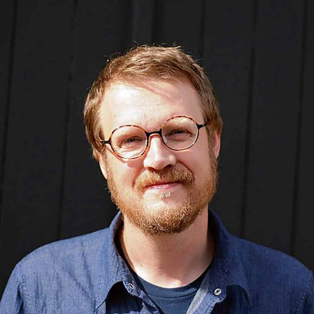 smiling man with glasses in a blue shirt digital production Smiling man with glasses in a blue shirt