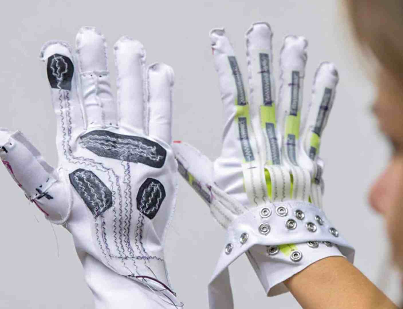 two hightech gloves with sensors displayed in front of a person digital production Two high-tech gloves with sensors displayed in front of a person.