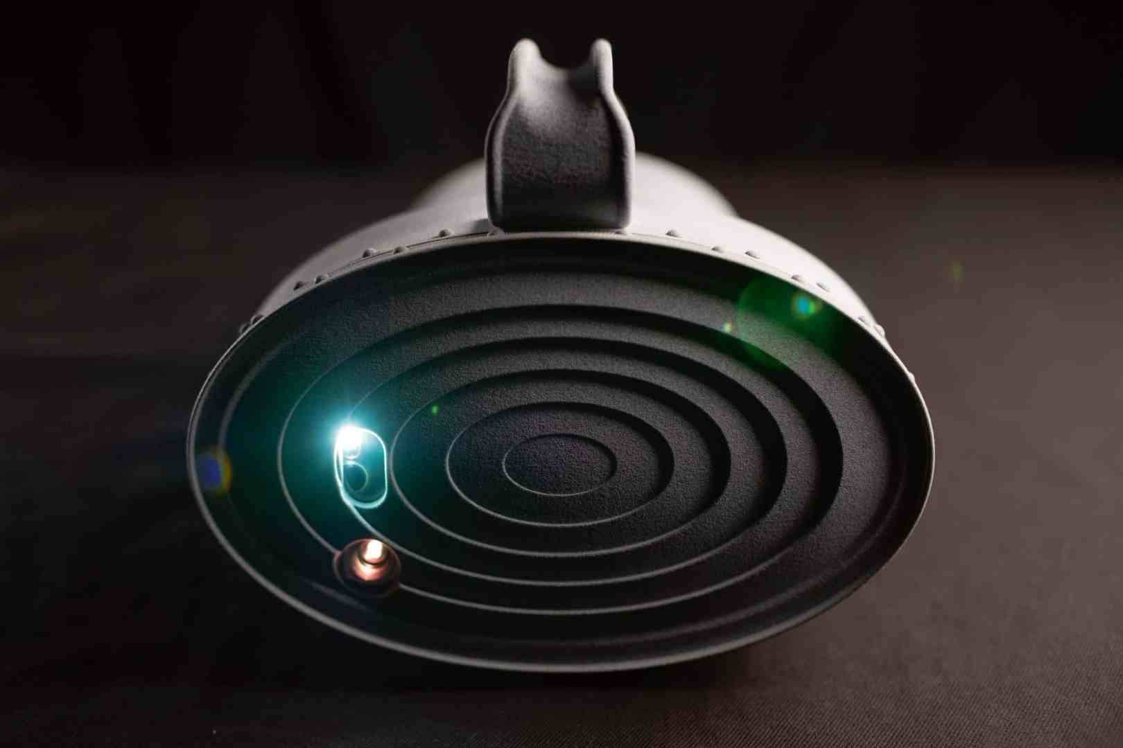 a black circular speaker with concentric grooves and led lights digital production A black circular speaker with concentric grooves and LED lights