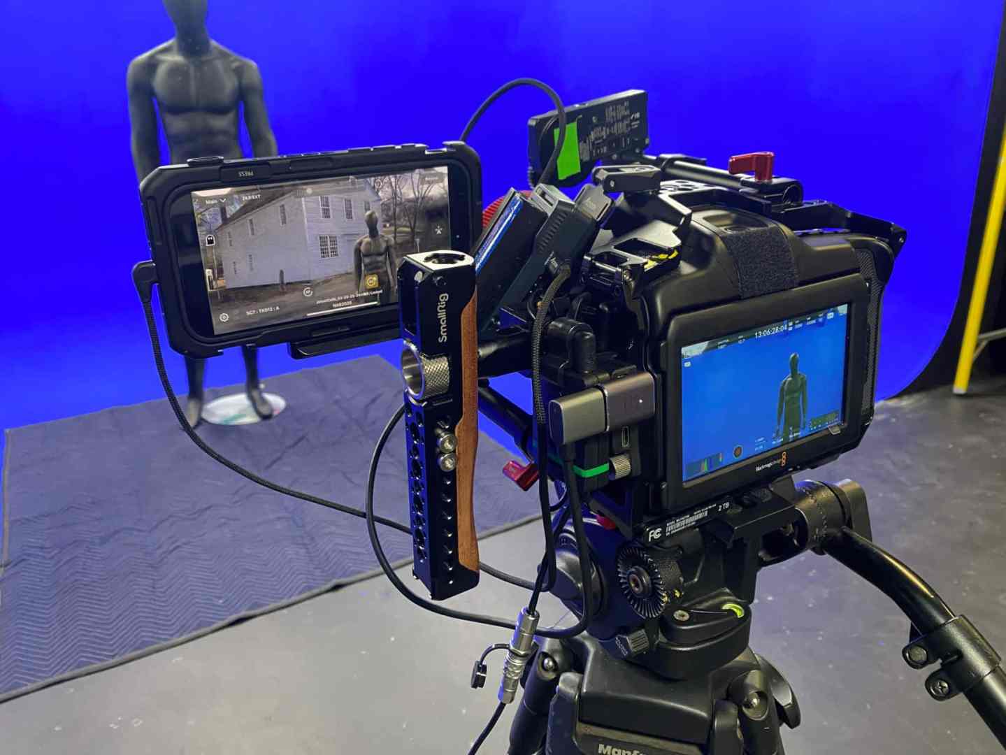 a camera setup with two screens one showing a live feed and the other a colored background a black mannequin is positioned in front of a blue screen showcasing the filming environment digital production A camera setup with two screens, one showing a live feed and the other a colored background. A black mannequin is positioned in front of a blue screen, showcasing the filming environment.
