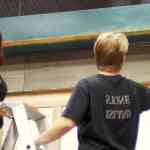 two people painting a blue wooden frame above a window one person is on a ladder with a paintbrush while the other is on the ground assisting both are wearing casual clothing digital production Two people painting a blue wooden frame above a window; one person is on a ladder with a paintbrush while the other is on the ground assisting. Both are wearing casual clothing.