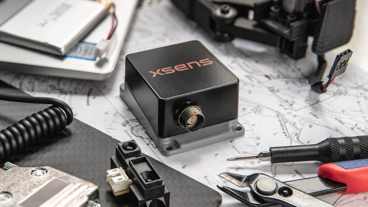 xsens sensor on a work table with tools and maps digital production https://www.movella.com/hs-fs/hubfs/Hero%20sirius%20launch%20final.png?width=1280&name=Hero%20sirius%20launch%20final.png