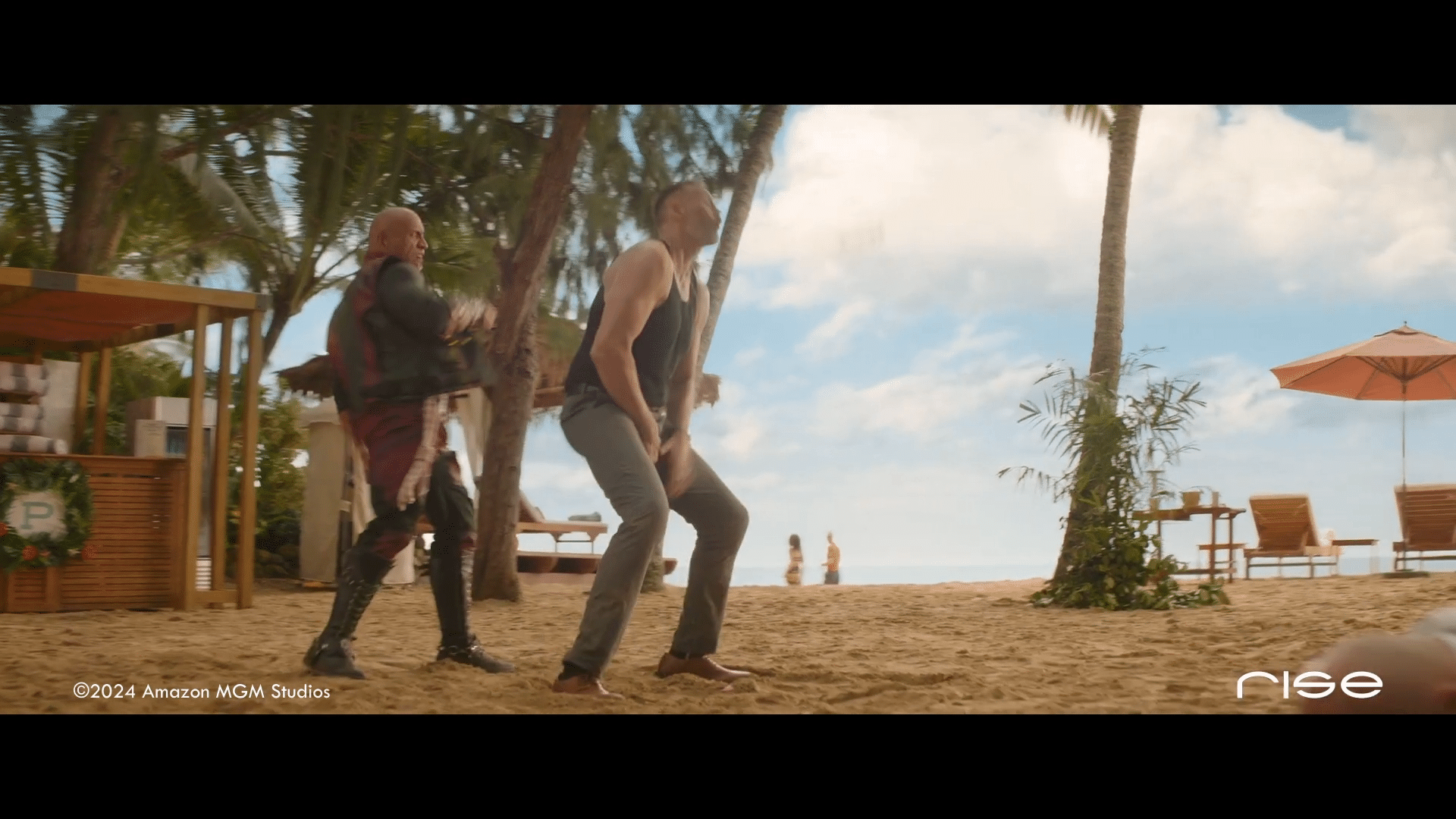 two men in casual beach attire on sandy beach with palm trees and lounge chairs in background digital production Two men in casual beach attire on sandy beach with palm trees and lounge chairs in background.