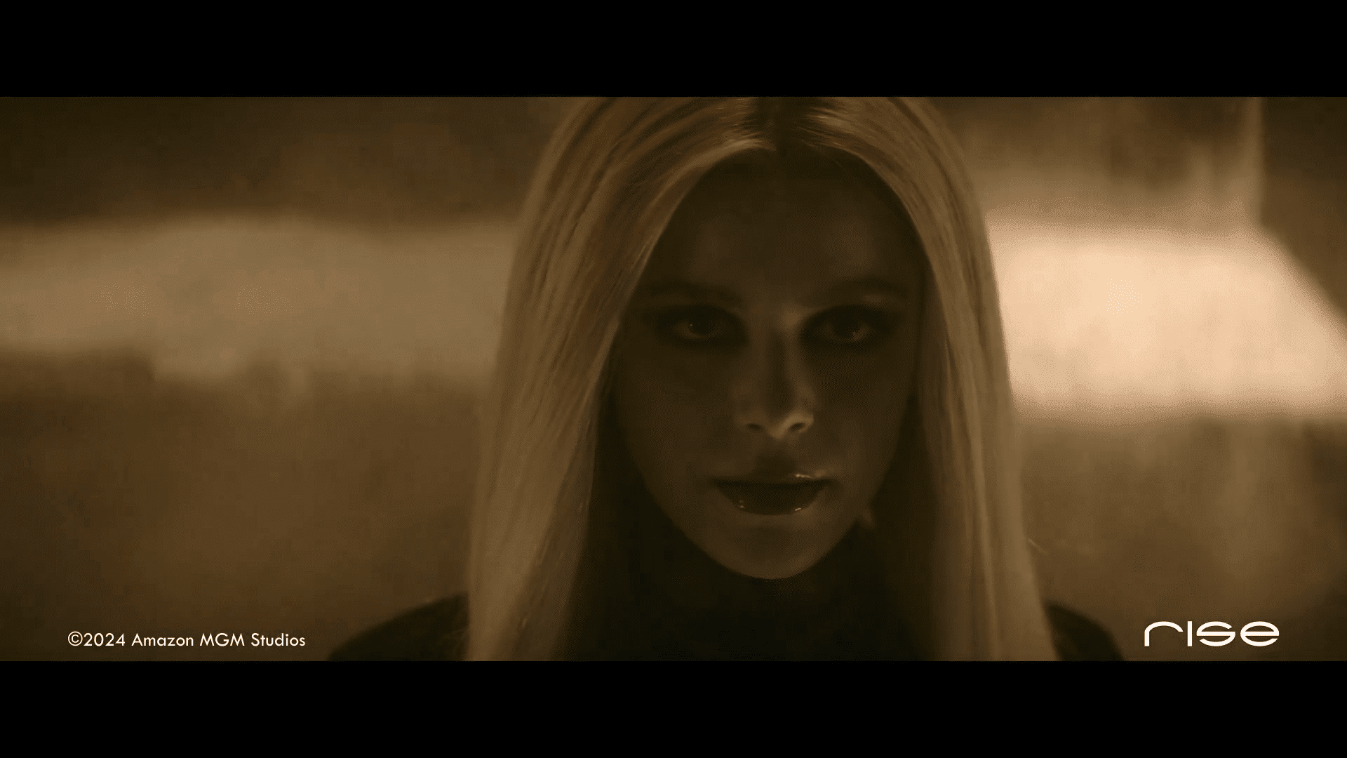 a woman with long blonde hair and dark makeup staring intensely at the camera digital production A woman with long blonde hair and dark makeup staring intensely at the camera.