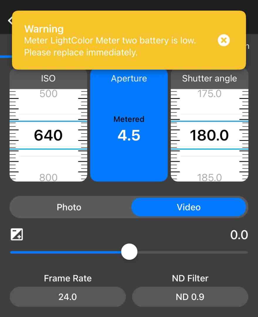 user interface of a light meter app displaying battery warning iso aperture and shutter angle settings digital production Mobile app interface of the LightColor Meter displaying low battery warning, with settings for ISO, aperture, shutter angle, and options for photo and video modes.