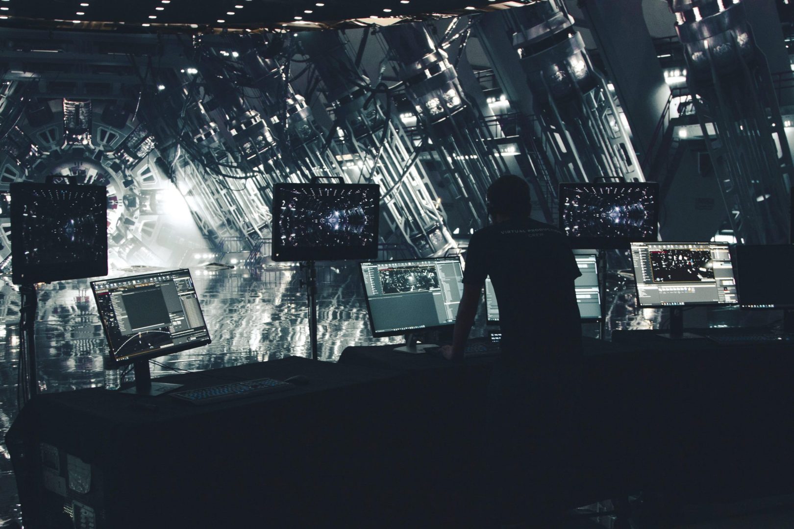 a person standing in front of a series of hightech monitors in a dimly lit futuristic environment the backdrop features reflective surfaces and intricate machinery creating a scifi aesthetic digital production A person standing in front of a series of high-tech monitors in a dimly lit, futuristic environment. The backdrop features reflective surfaces and intricate machinery, creating a sci-fi aesthetic.