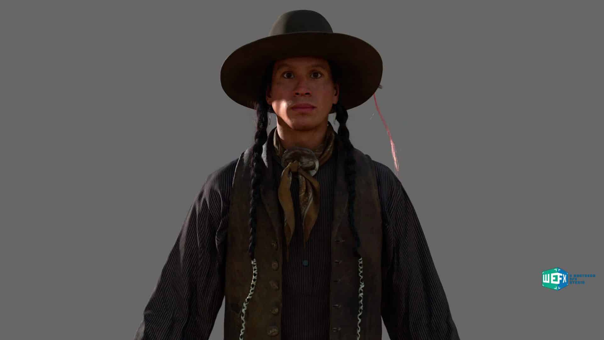 a person wearing a widebrimmed hat a dark vest over a collared shirt and a patterned neck scarf they have long braided hair and are standing against a neutral gray background digital production A person wearing a wide-brimmed hat, a dark vest over a collared shirt, and a patterned neck scarf. They have long braided hair and are standing against a neutral gray background.