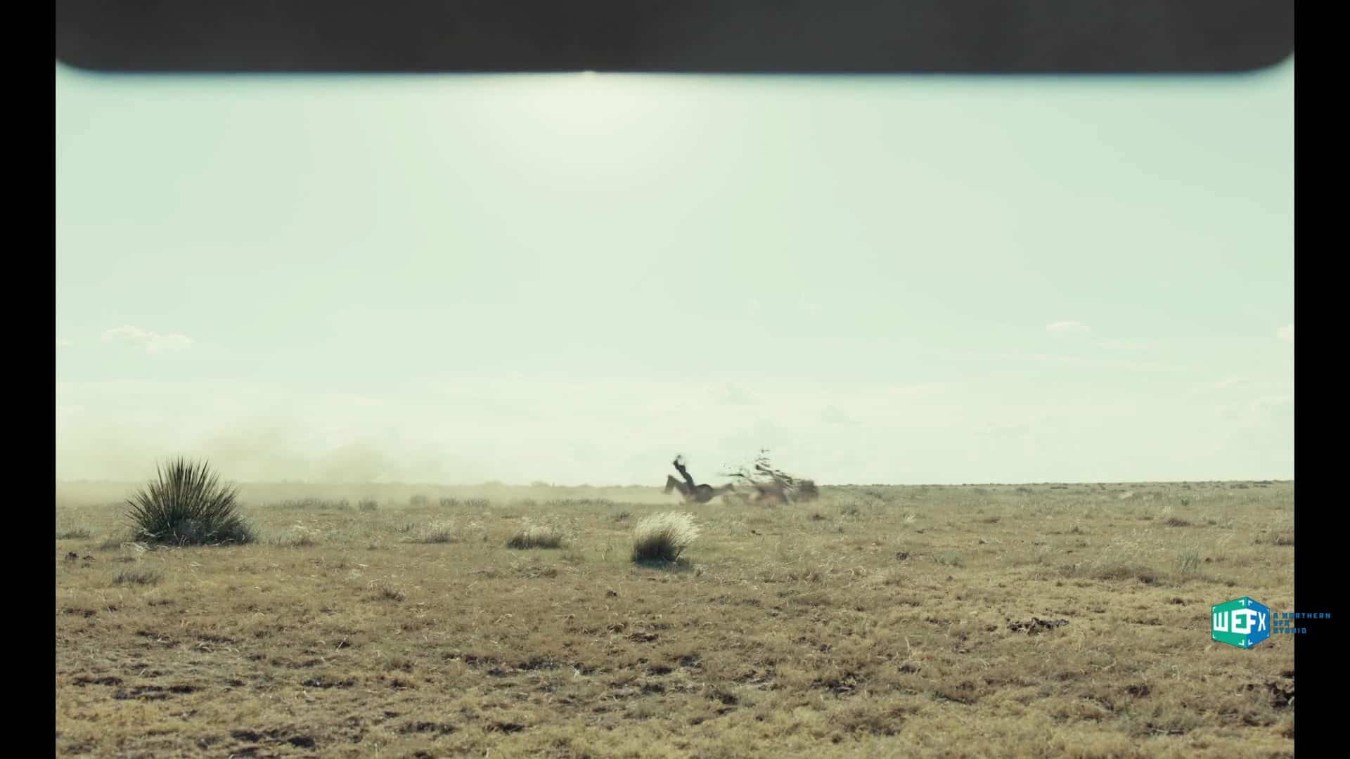 a cowboy riding a horse across an open field creating dust clouds with sparse vegetation visible in the foreground and a clear sky in the background digital production A cowboy riding a horse across an open field, creating dust clouds, with sparse vegetation visible in the foreground and a clear sky in the background.