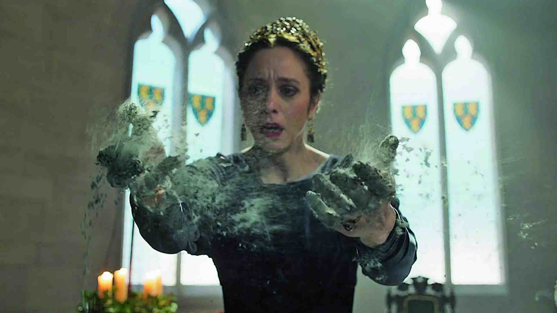 a woman in a dark dress with a crown showing an expression of shock holds her hands outwards with a cloud of dust or powder swirling around them in a castle interior with stained glass windows digital production A woman in a dark dress with a crown, showing an expression of shock, holds her hands outwards with a cloud of dust or powder swirling around them in a castle interior with stained glass windows.