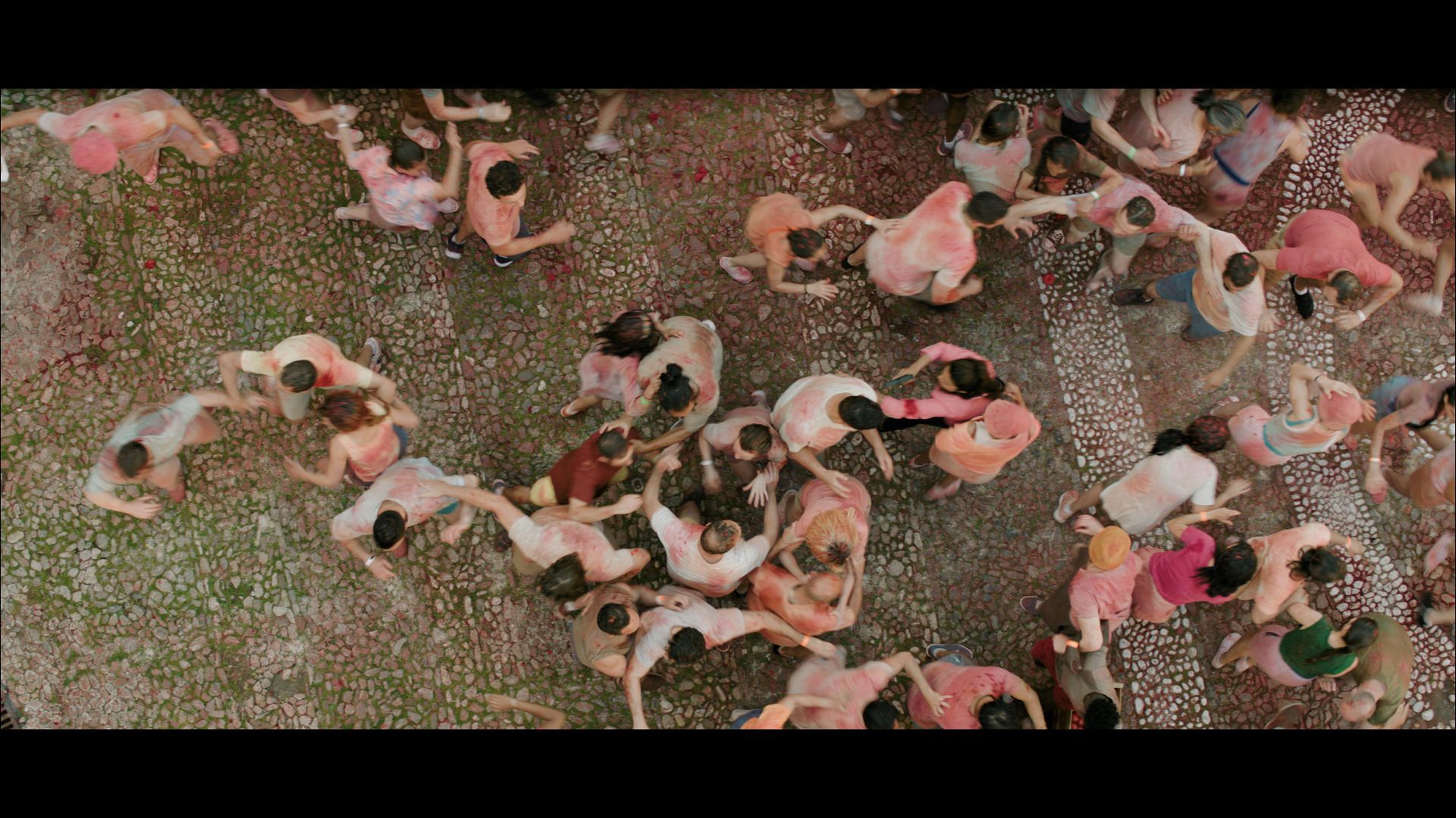 aerial view of a large crowd of people celebrating covered in vibrant colors gathered on a cobblestone street during a festive event digital production Aerial view of a large crowd of people celebrating, covered in vibrant colors, gathered on a cobblestone street during a festive event.