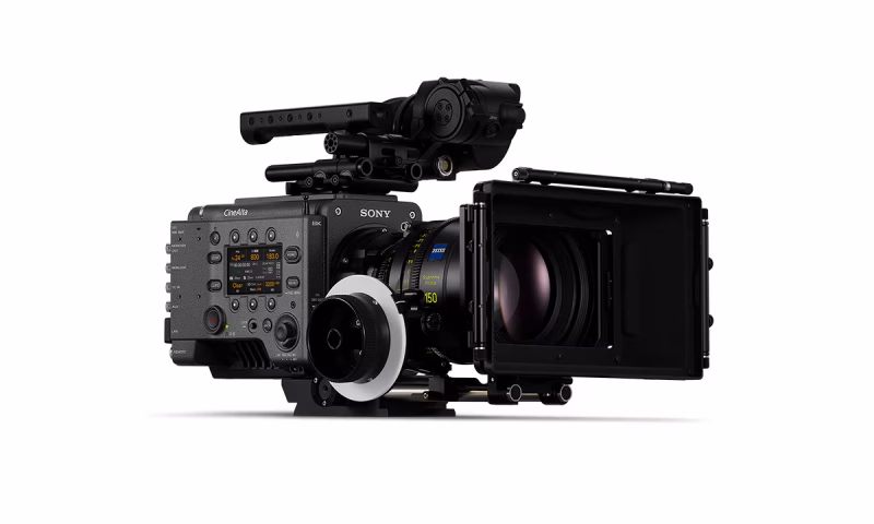 A professional cinema camera from Sony, featuring a large lens, a matte box, and control buttons on the side. The camera is mounted on a support rig for stability.
