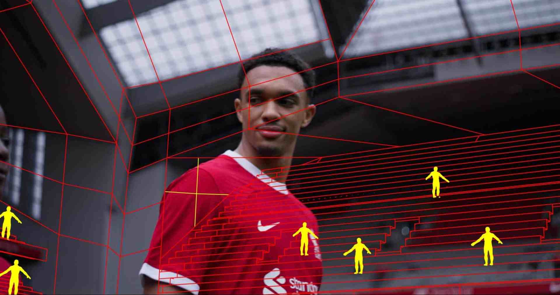 a player in a red jersey standing on a football pitch with a geometrical overlay showing yellow figures and red lines outlining the field the background shows stadium seating and a roof structure digital production A player in a red jersey standing on a football pitch, with a geometrical overlay showing yellow figures and red lines outlining the field. The background shows stadium seating and a roof structure.