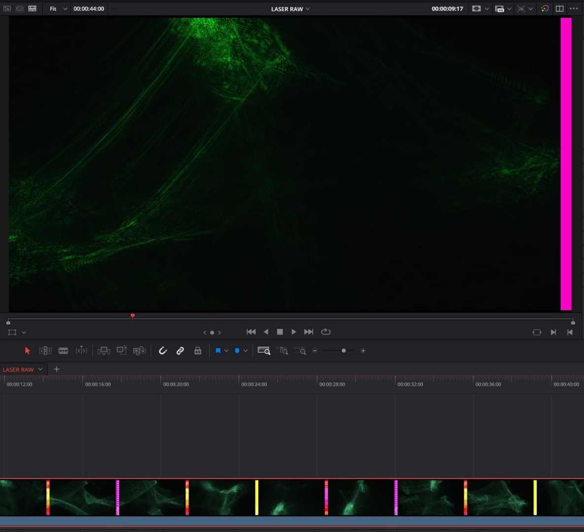 a digital video editing interface displaying a dark scene with green light streaks overlaid the top section shows a preview window while the bottom displays a timeline with clips marked in various colors including pink and yellow digital production A digital video editing interface displaying a dark scene with green light streaks overlaid. The top section shows a preview window, while the bottom displays a timeline with clips marked in various colors, including pink and yellow.