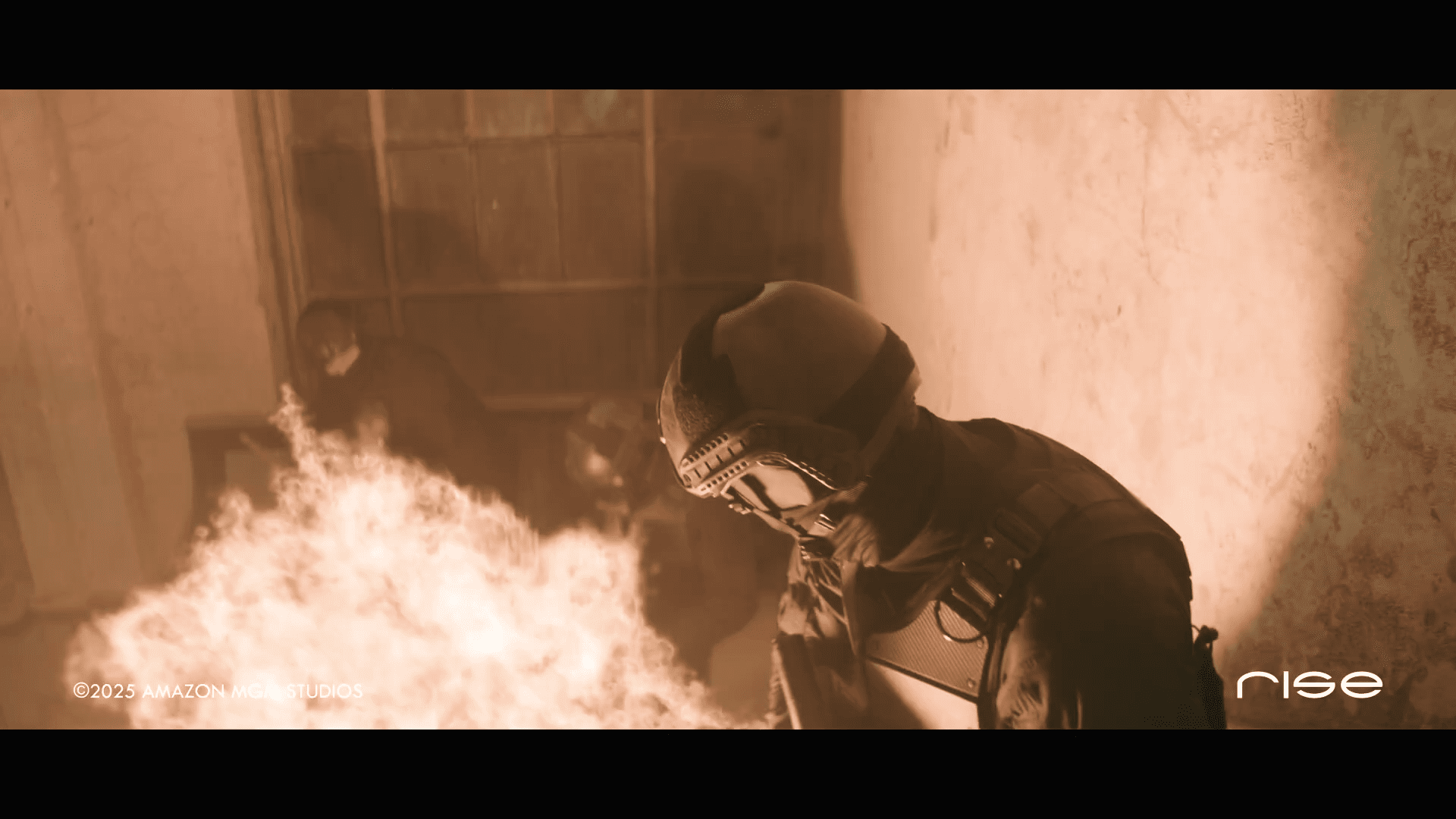 a person in a helmet and tactical gear stands amidst smoke and flames in a dimly lit room with faint silhouettes of others visible in the background the scene conveys an atmosphere of tension digital production A person in a helmet and tactical gear stands amidst smoke and flames in a dimly lit room, with faint silhouettes of others visible in the background. The scene conveys an atmosphere of tension.