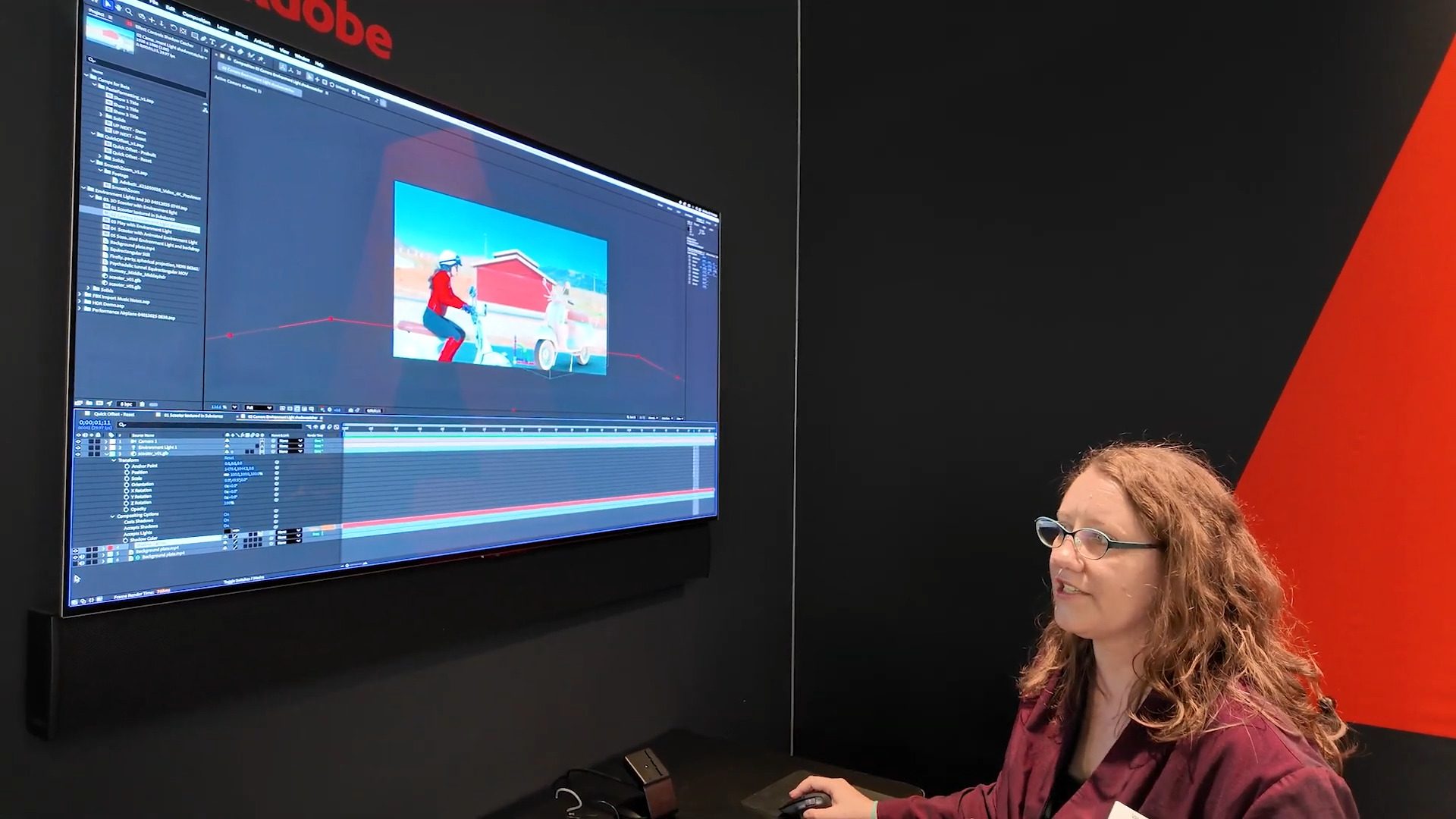 a woman with curly hair and glasses is focused on a computer screen displaying animation software the screen shows a colorful animated scene while she operates the software from a desk in a modern workspace digital production A woman with curly hair and glasses is focused on a computer screen displaying animation software. The screen shows a colorful animated scene, while she operates the software from a desk in a modern workspace.