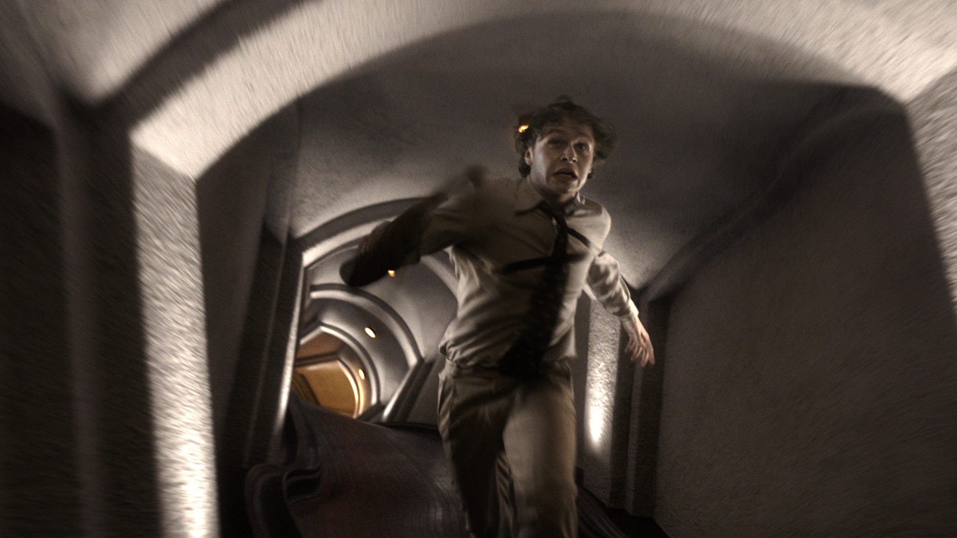 a man dressed in a lightcolored suit runs through a dimly lit curved tunnel with textured walls the scene captures a sense of urgency and motion with the figure slightly blurred as he speeds past digital production A man dressed in a light-colored suit runs through a dimly lit, curved tunnel with textured walls. The scene captures a sense of urgency and motion, with the figure slightly blurred as he speeds past.