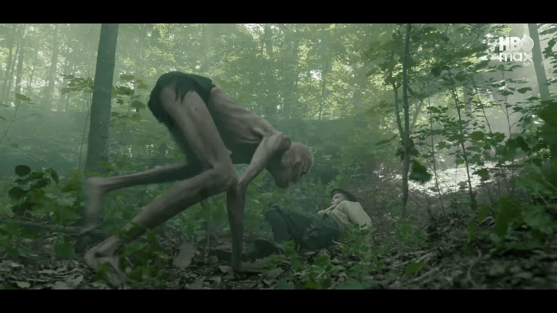 a tall emaciated creature with elongated limbs crouches in a misty forest while a person in a light shirt lies on the ground seemingly vulnerable among the dense greenery digital production A tall, emaciated creature with elongated limbs crouches in a misty forest, while a person in a light shirt lies on the ground, seemingly vulnerable among the dense greenery.