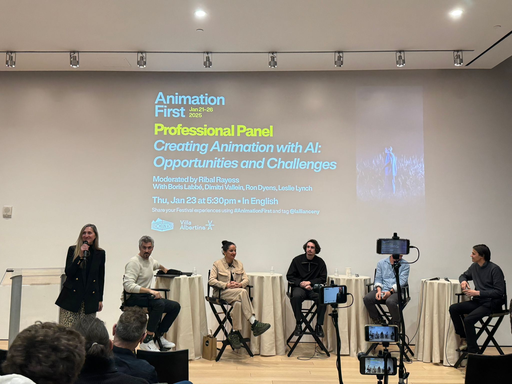 a professional panel discussing ai in animation featuring five speakers seated on stools the event details are projected on a screen in the background listing the panel title and moderator digital production A professional panel discussing AI in animation, featuring five speakers seated on stools. The event details are projected on a screen in the background, listing the panel title and moderator.
