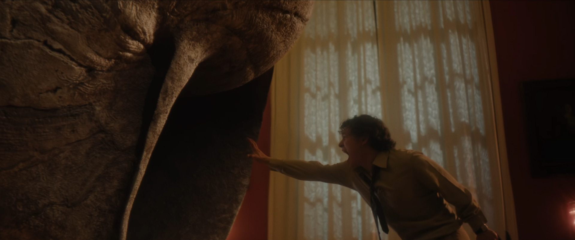 a person reaching out toward a large textured sculpture resembling a creature set against a softly lit interior with patterned curtains the scene conveys a sense of wonder and curiosity digital production A person reaching out toward a large, textured sculpture resembling a creature, set against a softly lit interior with patterned curtains. The scene conveys a sense of wonder and curiosity.