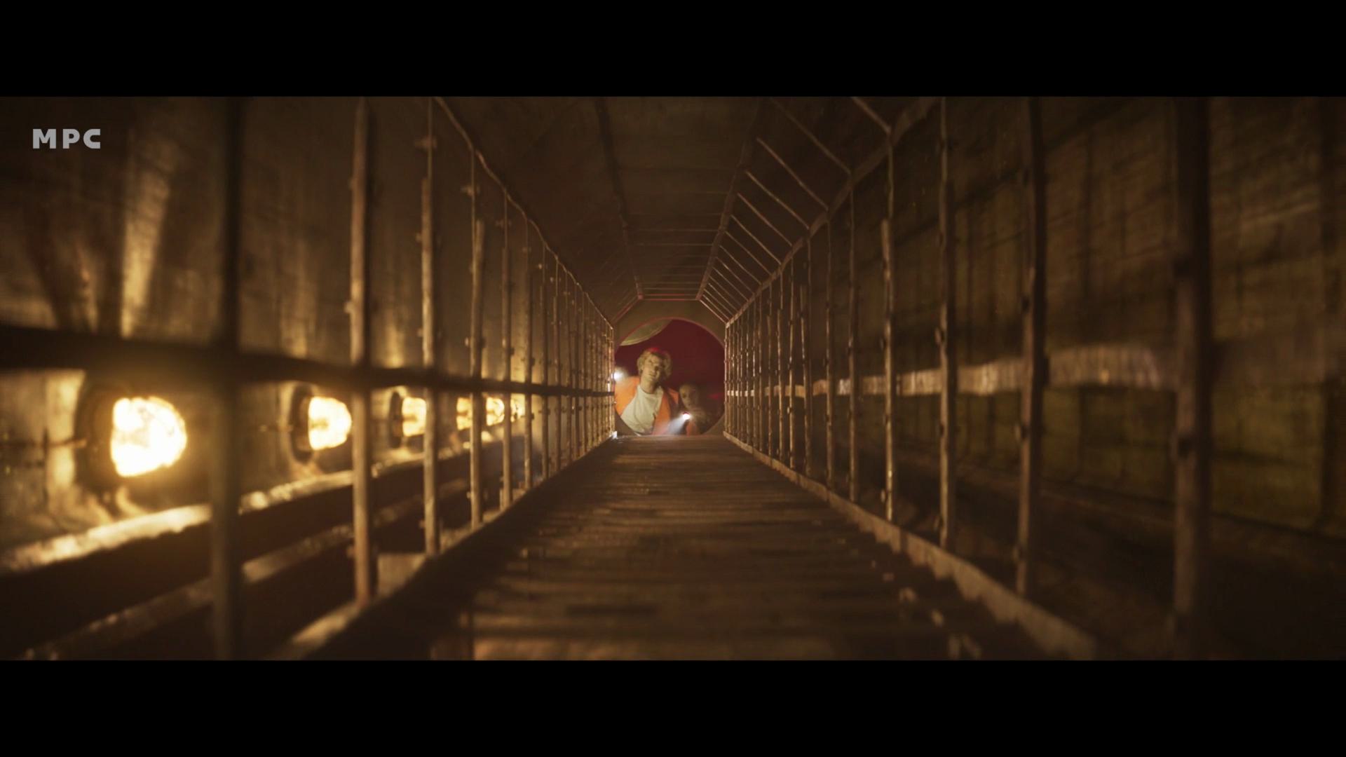 a narrow tunnel illuminated by warm lights along the sides showing a wooden walkway leading toward a shadowy area at the end the walls are textured and wooden enhancing the mysterious atmosphere of the scene digital production A narrow tunnel illuminated by warm lights along the sides, showing a wooden walkway leading toward a shadowy area at the end. The walls are textured and wooden, enhancing the mysterious atmosphere of the scene.