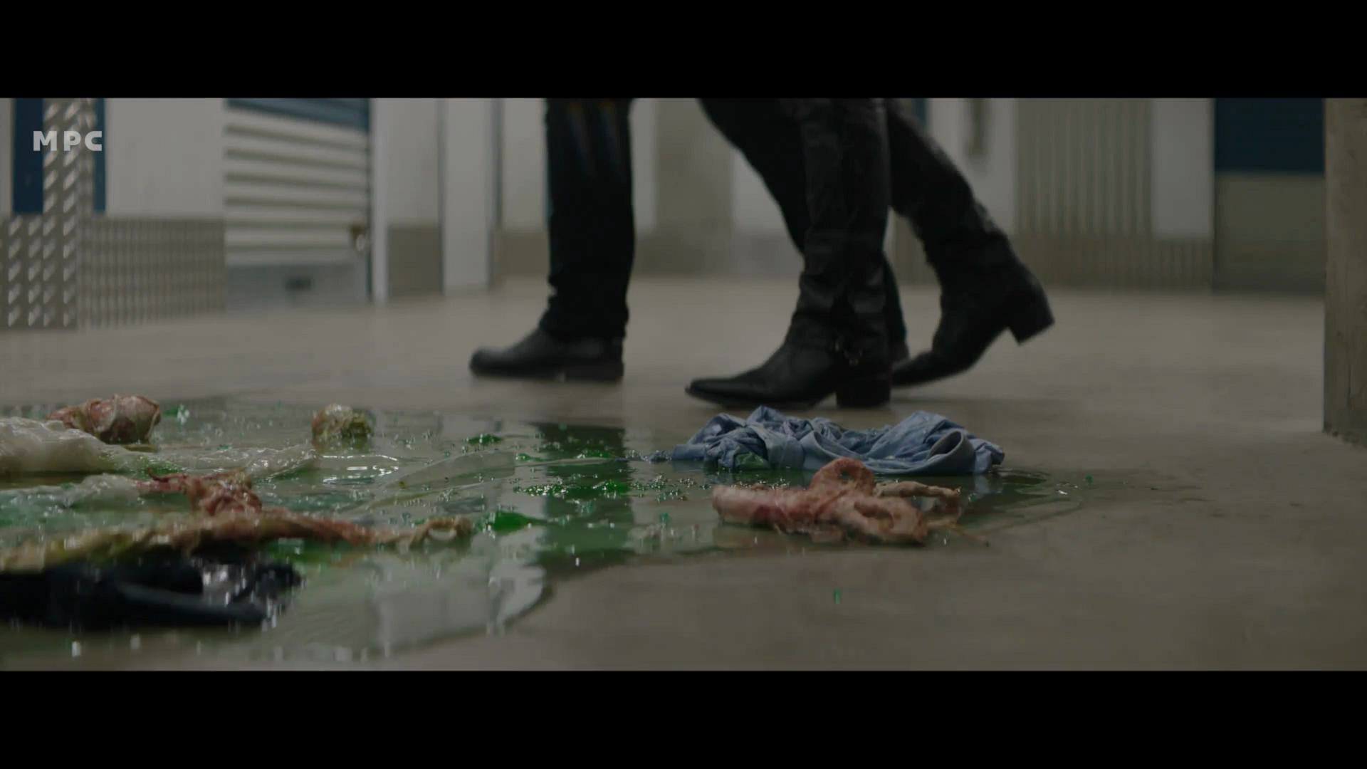 two pairs of black boots walking near a slick green puddle on a concrete floor with tattered clothing and debris scattered around digital production Two pairs of black boots walking near a slick, green puddle on a concrete floor, with tattered clothing and debris scattered around.