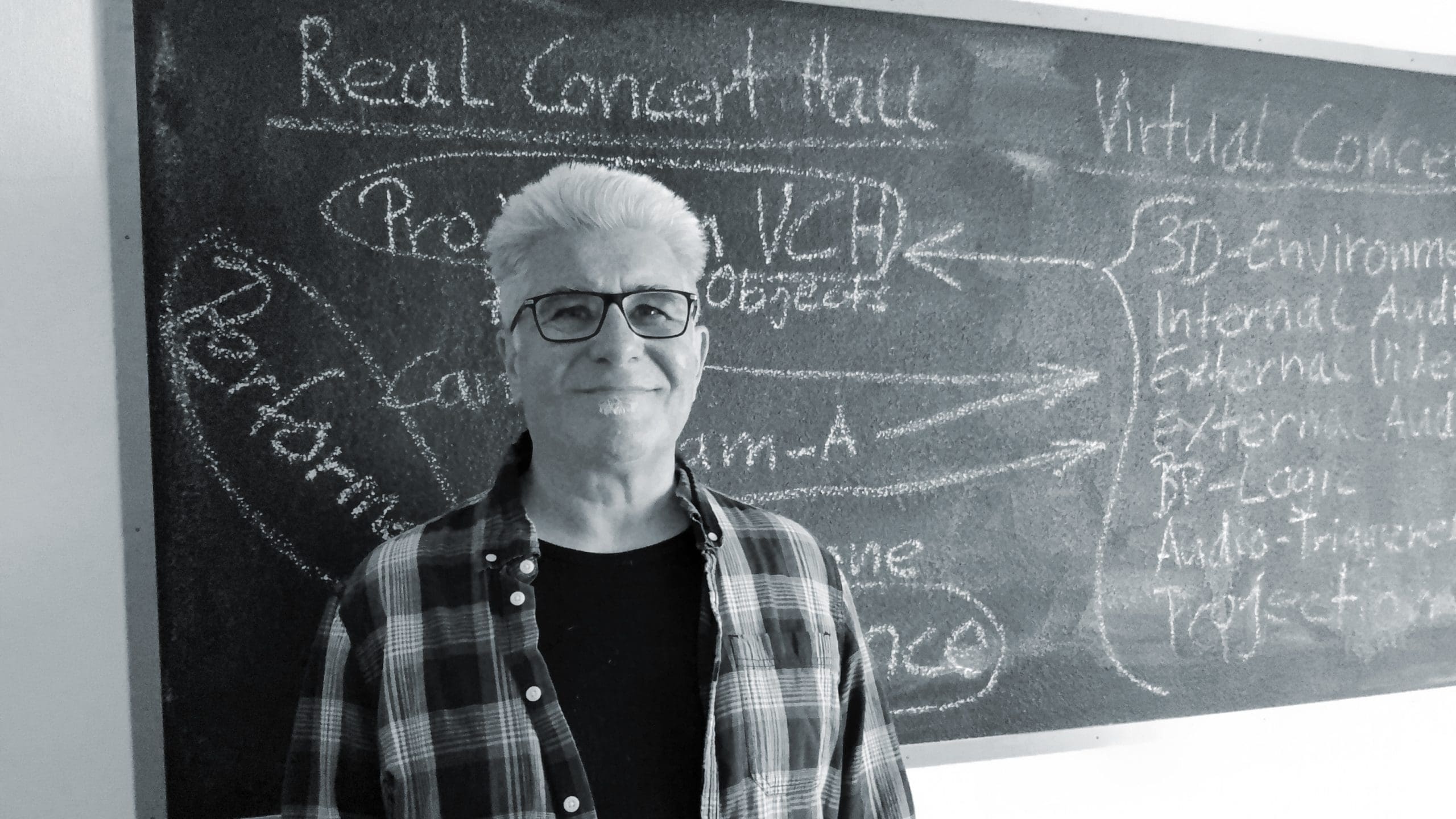 a middleaged man with gray hair and glasses stands in front of a chalkboard filled with writing the board outlines concepts related to real concert hall and virtual concert with various arrows pointing to items like performance and 3d environment creating an academic atmosphere digital production A middle-aged man with gray hair and glasses stands in front of a chalkboard filled with writing. The board outlines concepts related to 'Real Concert Hall' and 'Virtual Concert', with various arrows pointing to items like 'Performance' and '3D Environment', creating an academic atmosphere.