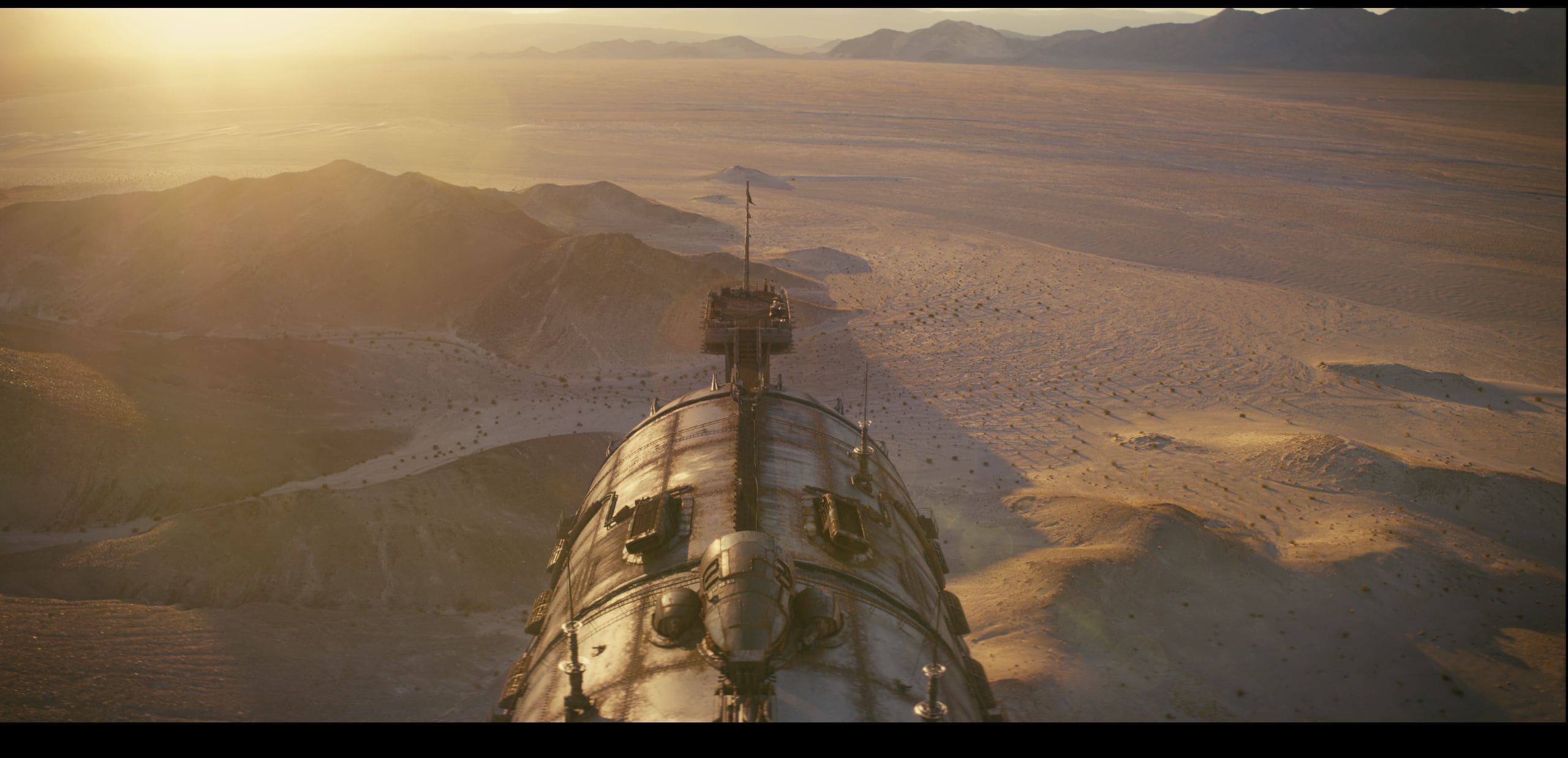aerial view of a sleek spacecraft with intricate details hovering over vast arid desert landscapes the sun casts a warm golden glow illuminating distant mountains and a sprawling sandy terrain evoking a sense of isolation and adventure in this expansive environment digital production Aerial view of a sleek spacecraft with intricate details, hovering over vast, arid desert landscapes. The sun casts a warm golden glow, illuminating distant mountains and a sprawling sandy terrain, evoking a sense of isolation and adventure in this expansive environment.