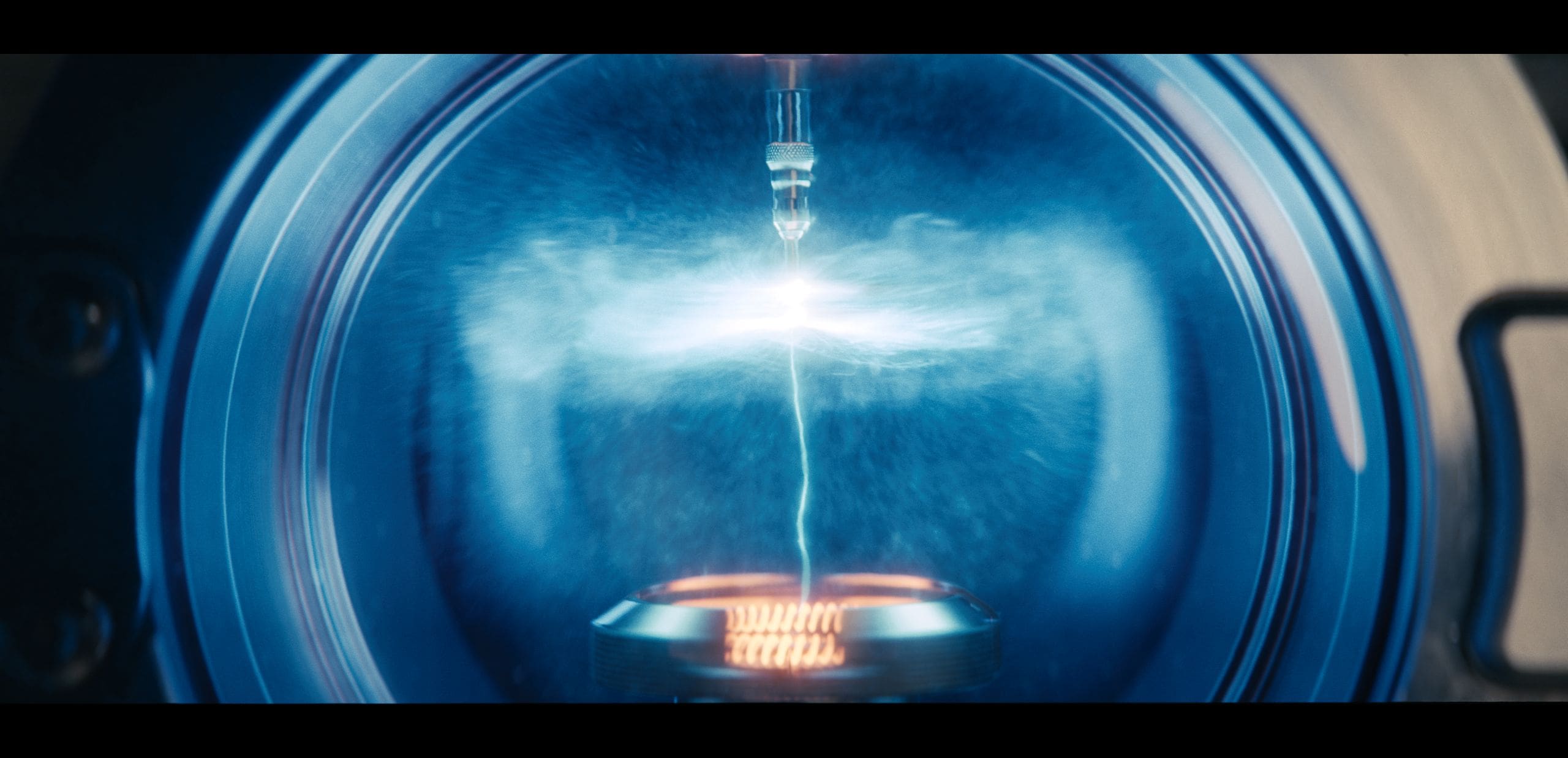 inside a futuristic metallic chamber a striking blue glow emanates from a cylindrical nozzle emitting an arc of vibrant energy wisps of mist swirl around highlighting the dynamic interplay of light and technology as the chamber pulses with electric anticipation digital production Inside a futuristic metallic chamber, a striking blue glow emanates from a cylindrical nozzle, emitting an arc of vibrant energy. Wisps of mist swirl around, highlighting the dynamic interplay of light and technology as the chamber pulses with electric anticipation.